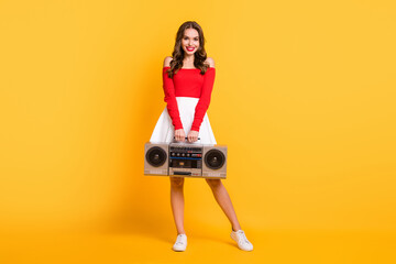 Full length body size photo girl keeping retro tape recorder listening music isolated on vibrant...