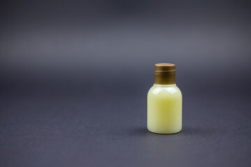 Photo of a yellow beautiful little bottle sitting in a black background