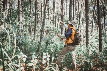 Male holding map for check location adventure in forest,  Holidays concept