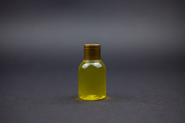 Photo of a little bottle of shower gel sitting in a back background