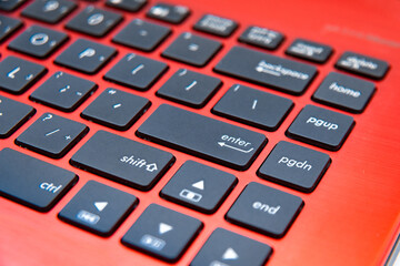 The black keyboard of the red laptop