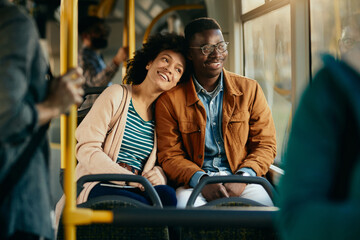 Happy African American couple relaxing while commuting by bus.