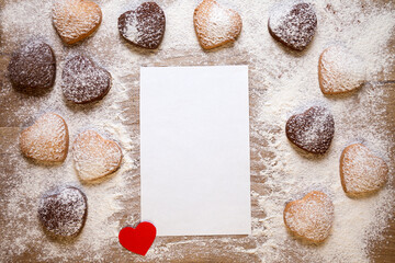 Fototapeta na wymiar Baking background with blank sheet of paper for the recipe or menu, heart shaped cookies, eggs, flour and small red paper heart. Empty space for text. Valentines Day