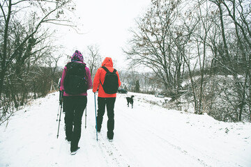 Group of hikers walking on the hike trail on snow winter day.