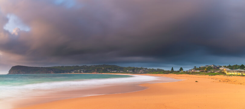 Sunrise at the seaside with rain clouds rolling in