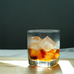 ice cold brew coffee drink in glass on wood with dark blue wall background