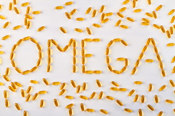 Word omega made of yellow capsules. Isolated on white background.