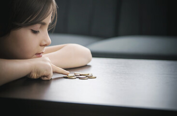 Child counts coins, poverty concept. Selective focus.
