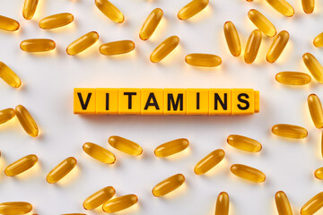 Yellow vitamins on white. Many omega pill capsules.