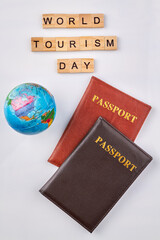 International passports and globe. World tourism day made from wooden letter blocks on white background.