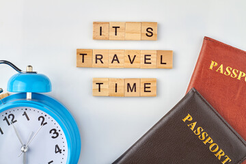 Time to travel. Wooden cubes with letters is making words. Passports and clock on white background.