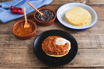 Huevos rancheros Mexican breakfast on a wooden base. Mexican cuisine. Copy space.