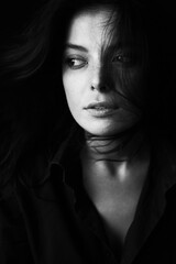 Fototapeta premium Emotional Sensual black and white portrait of a beautiful girl on a dark background