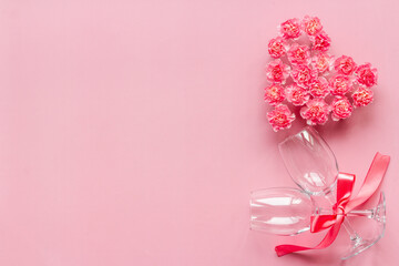 Valentines Day dating dinner with wine glasses and pink flowers. Wedding or birthday background