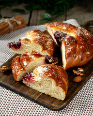 Buns with jam on a wooden table. Pie with cherry jam and marzipan. Rustic delicious pastries