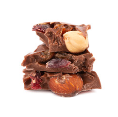 Chocolate pieces stack with nuts and berries, isolated on white background. Close up.