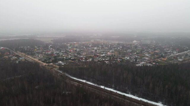 Aerial reveal of countryside village housees descending from clouds
