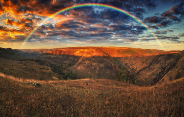 Rainbow with clouds over the canyon. autumn landscape