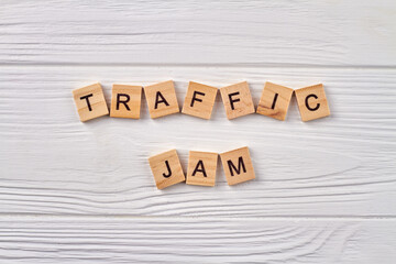 Traffic jam concept. Line of road traffic. Alphabet cubes with letters isolated on light wooden background.