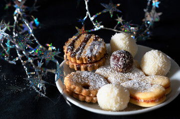 Christmas cookie with glittering chain on dark.