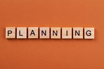 Effective planning for projects success. Letters on wooden cubes isolated on orange background.