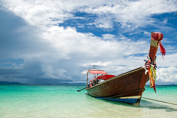 Fototapeta na wymiar Beautiful seascape with azure water of the Adaman Sea with blue sky and clouds. Traditional boats: longteyla. Thailand.