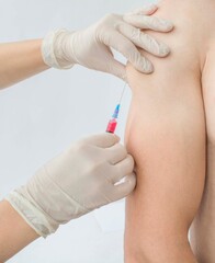 a nurse makes a vaccination, injects a medicine, a patient, a close-up, a syringe, hands, gloves.