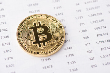 Close up view photo of one golden bitcoin lying on rate numbers