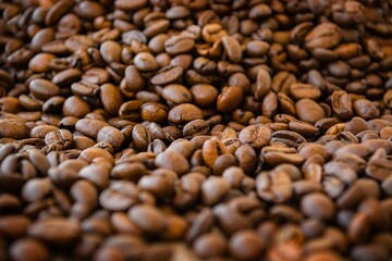 A scattering of natural roasted brown coffee beans. background.