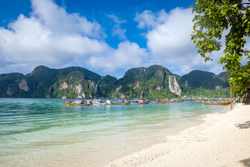 Fototapeta premium Beautiful seascape with azure water of the Adaman Sea with blue sky and clouds. Traditional boats: longteyla. Thailand.