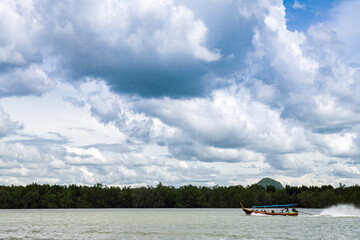 Beautiful seascape with azure water of the Adaman Sea with blue sky and clouds. Traditional boats: longteyla. Thailand.