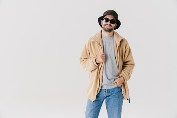 Joyful handsome guy in sunglasses smiling and looking at camera