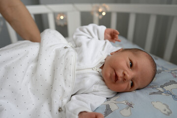 One week newborn adorable innocent baby lying at baycot and funny yawning.Portrait of sleepy...