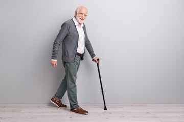 Full size profile photo of optimistic old man go with wand wear dark sweater trousers isolated on...