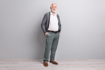 Full size photo of old optimistic man stand wear dark sweater trousers boots isolated on grey wall