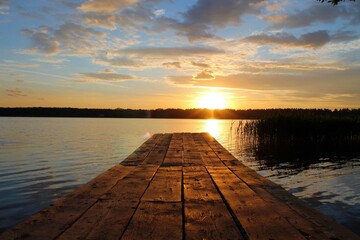 Obraz na płótnie Canvas Wooden jetty on the lake at sunset.