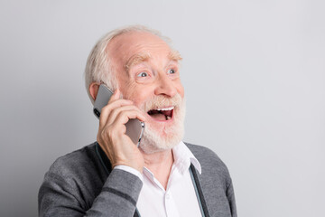 Portrait of old white hair optimistic man look empty space talk telephone write telephone wear dark sweater isolated on grey background