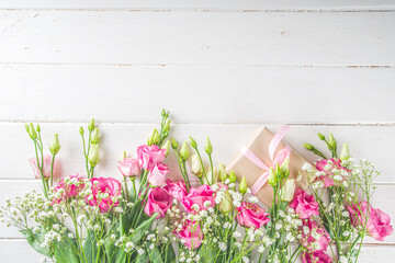 Beautiful spring flowers on white wooden background. Festive floral composition with craft paper  gift boxes. Valentine's day, Womans day, mothers day greeting card . Top view flat lay