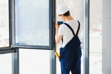 male industrial builder worker at window installation in building construction site