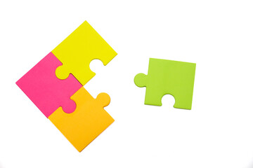 Three different colored pieces of puzzle are put together and one apart from them, isolated on a...