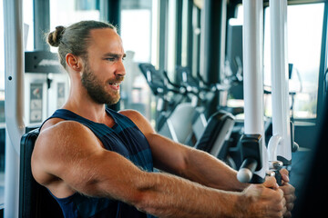 Fit man exercising at the gym on a machine