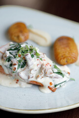 Salmon fillet with mushroom cream sauce on a plate. Exquisite dish close-up.