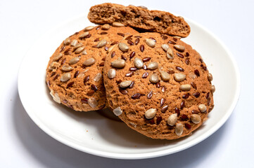Fresh oatmeal cookies, gingerbread on a plate. Oatmeal gingerbreads sprinkled with sunflower and flax grains close up