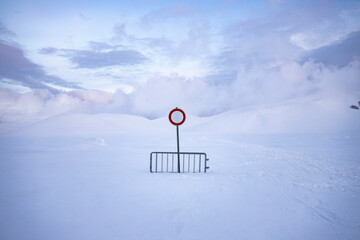 
no entry or transit, on a snow-covered road, over one meter of snow. desolation and silence in an...