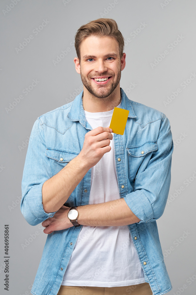 Wall mural handsome happy young man showing blank bank cor discount card