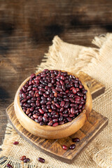 Red beans. Raw red beans in a wooden bowl on a brown wooden table. Organic Natural Vegetarian product	