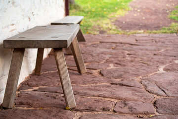 Fototapeta premium Empty bench on a colonial flagstone porch