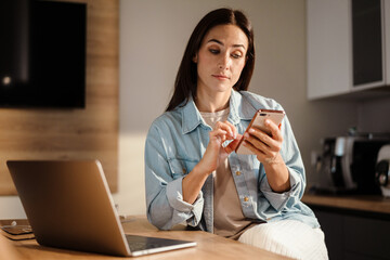 Beautiful woman using mobile phone and laptop computer