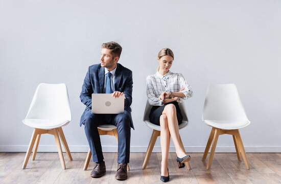 Business people with laptop and wristwatch waiting job interview in office