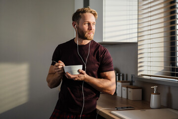 Attractive healthy young man having tasty breakfast
